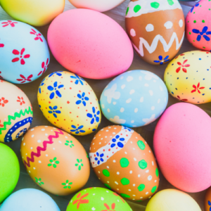 Zoomed in photo of brightly colored Easter Eggs, solid color and painted designs